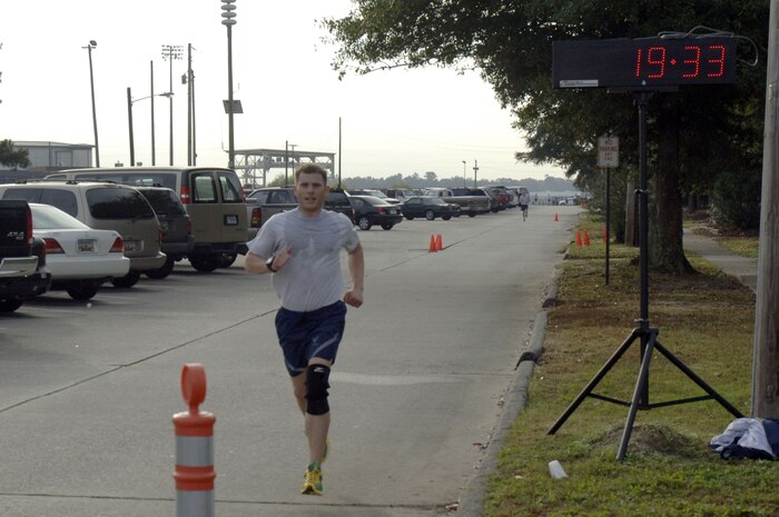 Bob Hardenstine makes a strong finish during the  Run the Runway 5K event honoring retired Brig. Gen. Thomas Mikolajcik here on Wingman Day Nov. 17. The first place male finisher was recognized with a trophy at the event and his name will be placed on another trophy, which will be on display at the Child Development Center. Hardenstine is assigned to the 15th Airlift Squadron and finished the 5K in 19:33. (U.S. Air Force photo/Staff Sgt. Marie Brown)