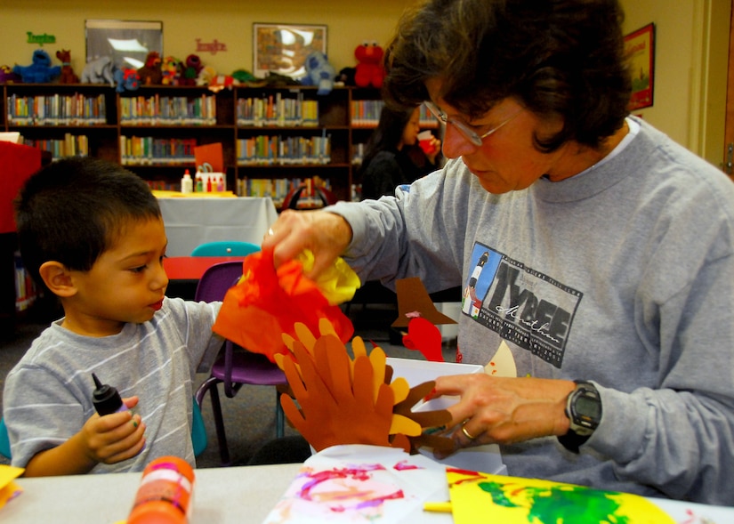 Gregory and Nitsa Calas work together during Family Craft Night at the Base Library here Nov. 12. Mrs. Calas attended the craft night after visiting the library find a few children's books for her grandson. Mrs. Calas is the wife of Army Ch. Capt. Lyde Calas who is deployed to the Middle East. (U.S. Air Force photo/Staff Sgt. Daniel Bowles)
