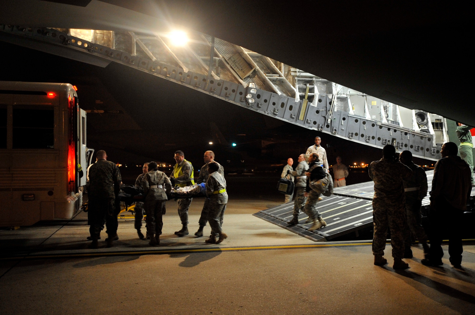 Members of the 779th Aeromedical Staging Facility transport patients from a C-17 Globemaster to a National Naval Medical Center patient transport bus Nov. 10, 2009, on the flightline at Joint Base Andrews, Md. The team receives three flights per week containing over 50 patients from overseas, both war wounded and ill, that are returning for medical care. (U.S. Air Force photo by Staff Sgt. Renae Kleckner)