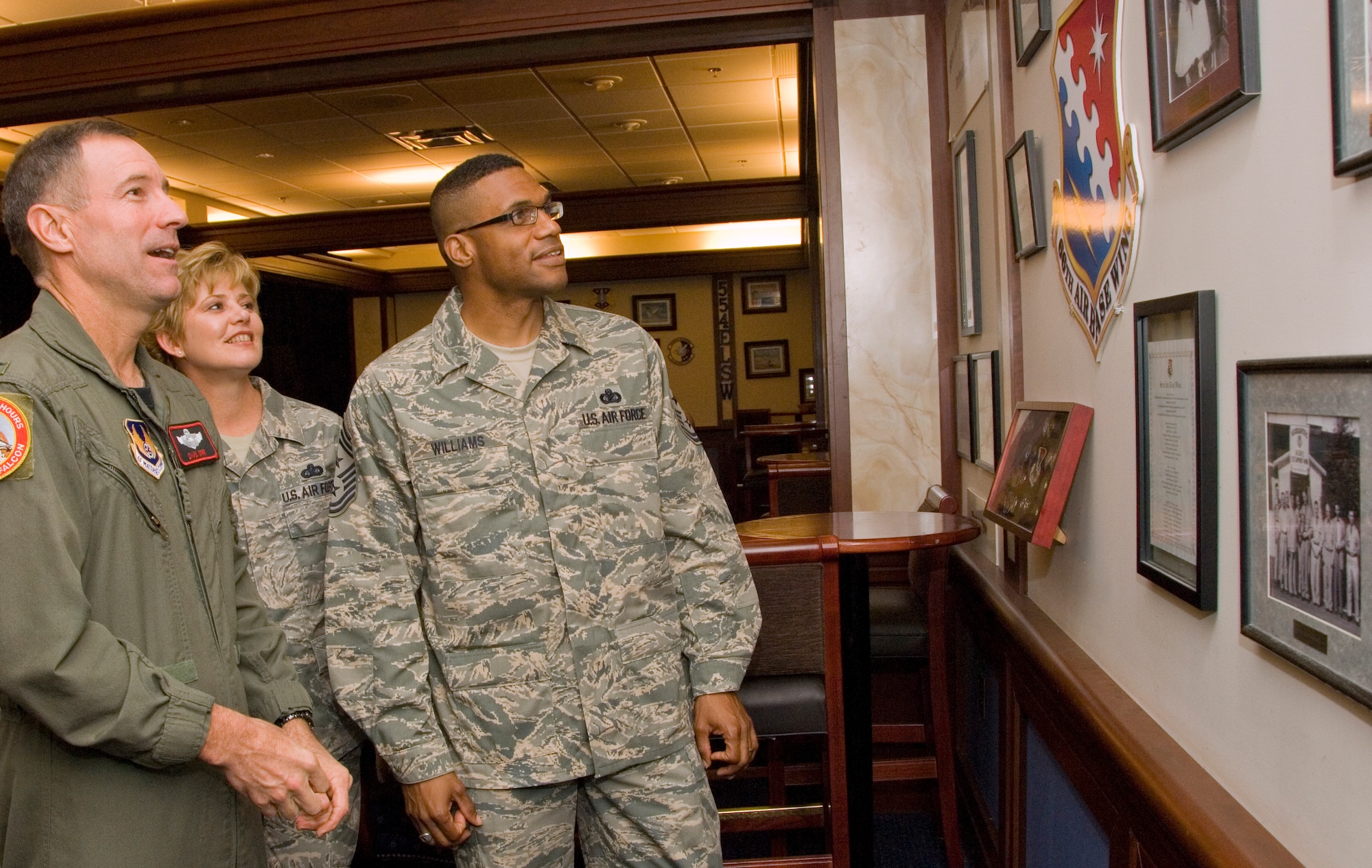 Chief Master Sergeant Kenneth Williams (right), Electronic Systems Center's new Command Chief, checks out the heritage wall at Hanscom's Minuteman Club with 66th Air Base Wing Commander Col. David Orr and Chief Master Sergeant Ginger Thompson of the 66th Medical Group.