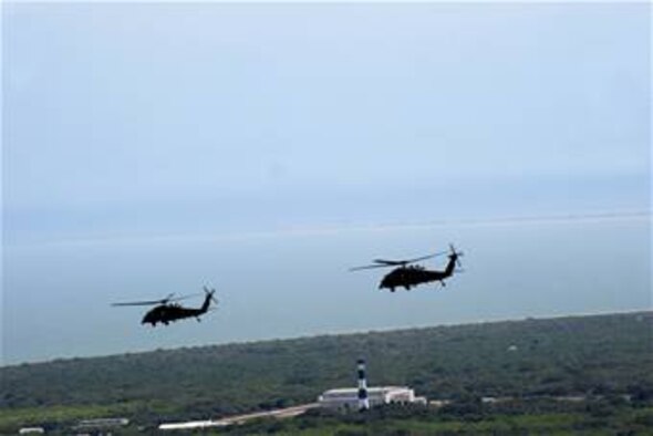 PATRICK AIR FORCE BASE, Fla. - From two to four HH-60G Pave Hawk helicopters piloted by Air Force Reservists of the 920th Rescue Wing here supoort everyshuttle launch from Florida's space coast. Seen here, two helipcoters race by the historic lighthouse of the Cape Canaveral Air Force Station prior to launch support. (U.S. Air Force photo/Tech Sgt. Gillian M. Albro)