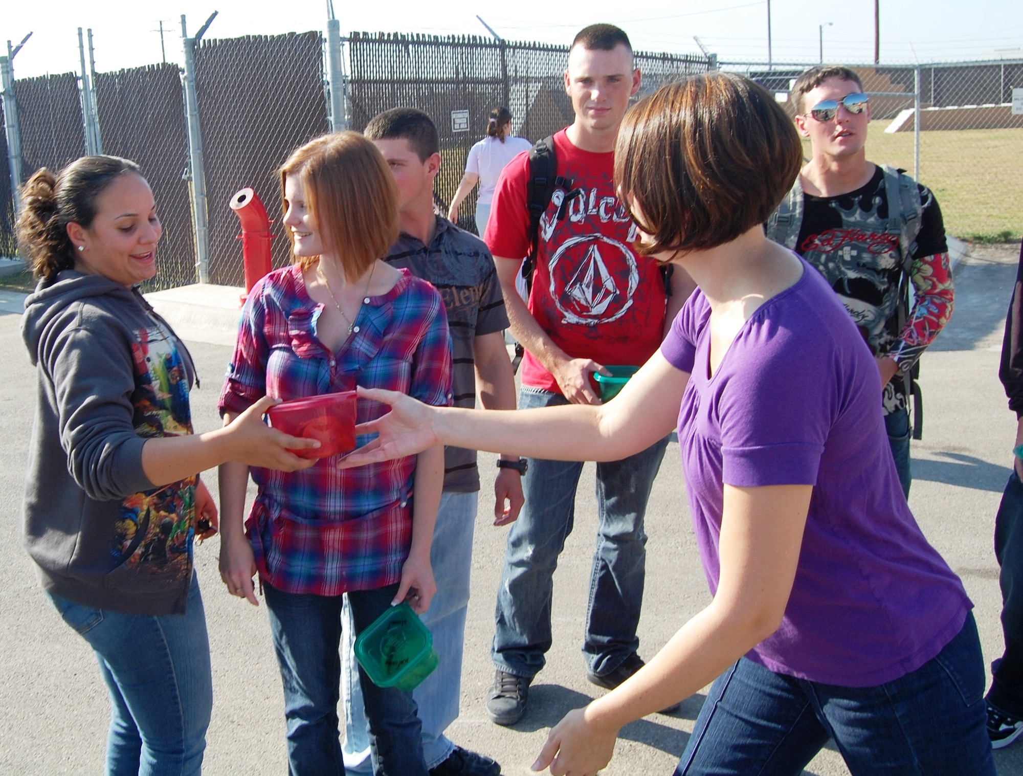 Mrs. Andia Dinesen, wife of Capt. Ian Dinesen, 47th Security Forces Squadron commander, presents Airman 1st Class Marisel Kigembe with cookies as Mrs. Shannon Booth and Airmen 1st Class Gregory Booth, Jacob Southall and Joshua Prange look on after members of the 47th Security Forces Squadron return from a deployment to Al Udeid Air Force Base in Southwest Asia where they preformed base security. (U.S. Air Force photo by Joel Langton)

