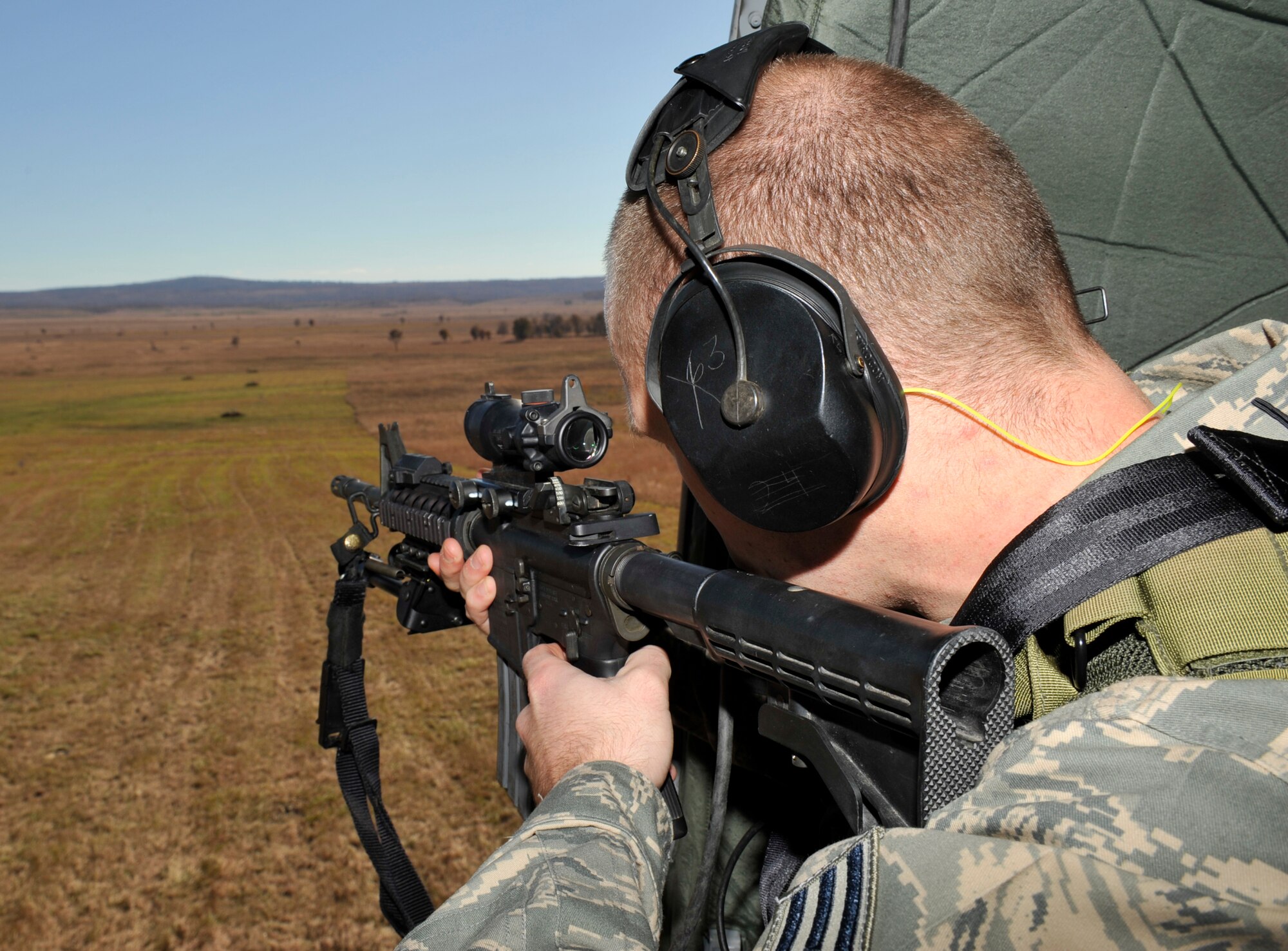 Senior Airman Dane Coppini, 19th Security Forces Squadron support staff and sharp shooter, searches for a target while in a Blackhawk helicopter at Fort Chaffee, Ark., Nov. 2. (U.S. Air Force photo by Airman 1st Class Lausanne Pacheco)