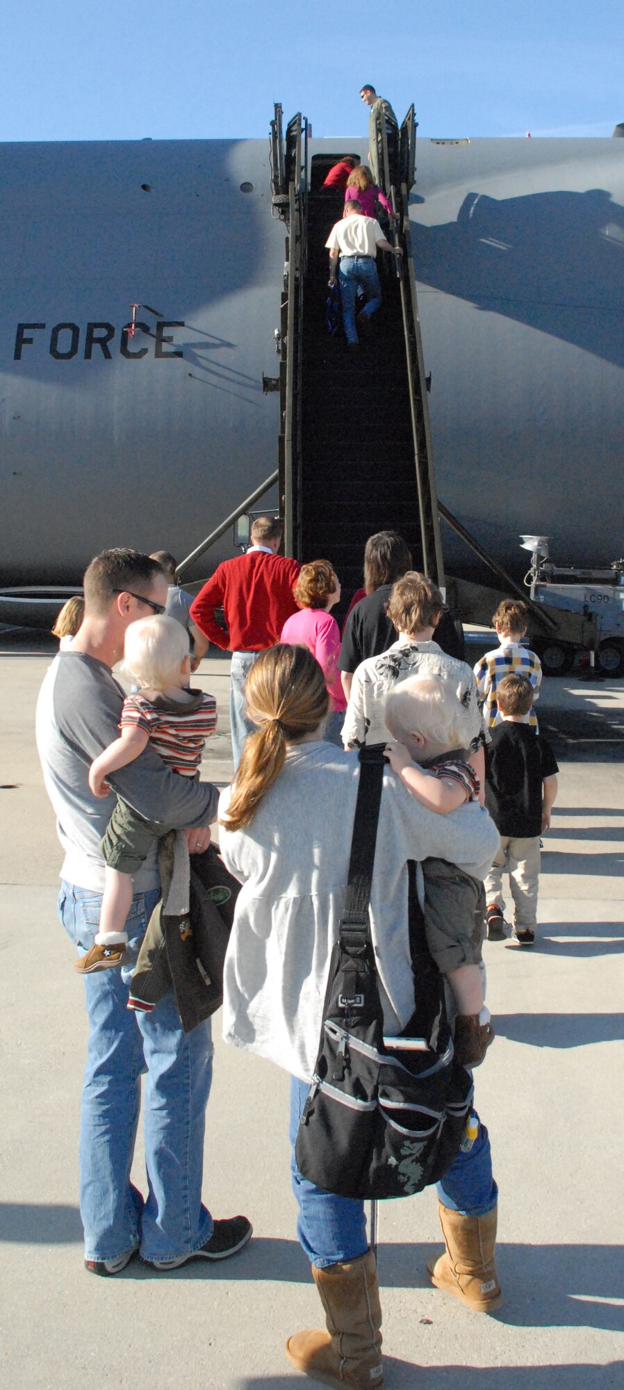 Families line up to enter the cabin of a C-5B Galaxy Nov. 15.  After the families took a photo with Santa in the cargo hold of the aircraft they were able to take a second photo with him inside the cabin.  The pictures with Santa were one of many programs Team Dover is highlighting during the Year of the Air Force Family.  (U.S. Air Force Photo/Staff Sgt. Chad Padgett)