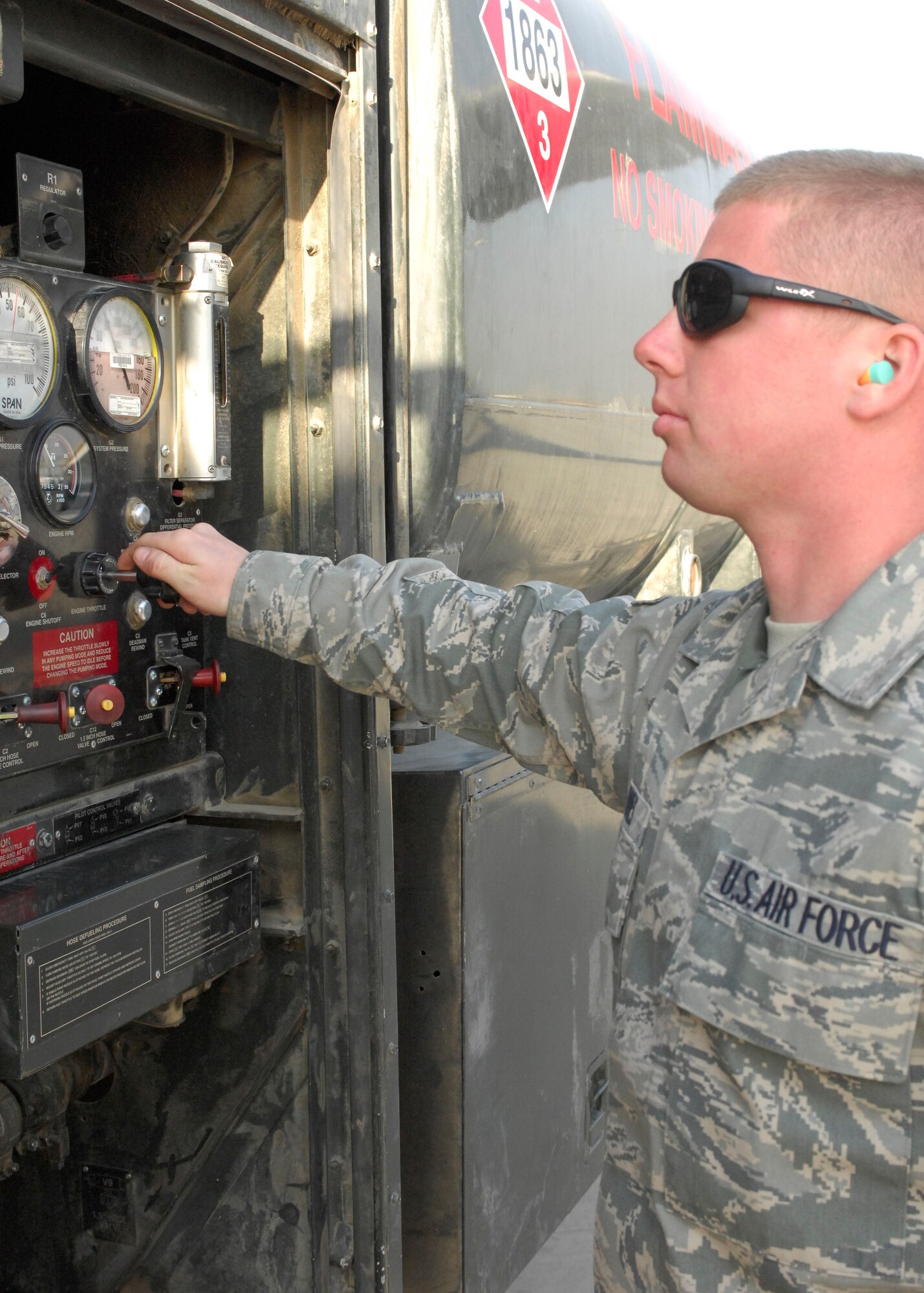 BAGRAM AIRFIELD, Afghanistan -- Senior Airman Jacob Barnes, a fuels journeyman from the 455th Expeditionary Logistics Readiness Squadron, checks settings on his truck after fueling a C-17 Globemaster III waiting to load cargo for troops in the field, Nov. 17, 2009. Airman Barnes is from Detroit, Mich., and is deployed from Andersen Air Force Base, Guam. (U.S. Air Force photo/Senior Airman Susan Tracy)