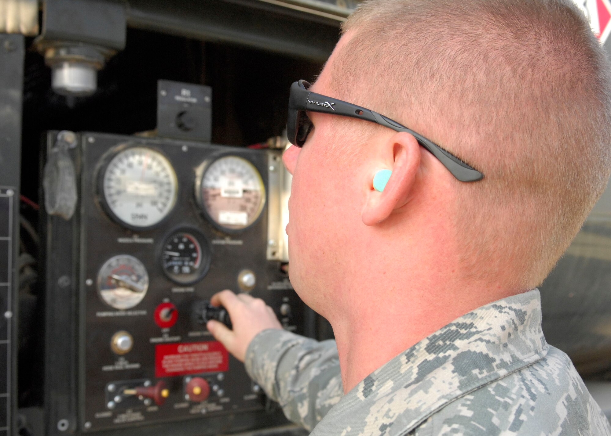 BAGRAM AIRFIELD, Afghanistan -- Senior Airman Jacob Barnes, a fuels journeyman from the 455th Expeditionary Logistics Readiness Squadron, checks settings on his truck after fueling a C-17 Globemaster III waiting to load cargo for troops in the field, Nov. 17, 2009. Airman Barnes is from Detroit, Mich., and is deployed from Andersen Air Force Base, Guam. (U.S. Air Force photo/Senior Airman Susan Tracy)