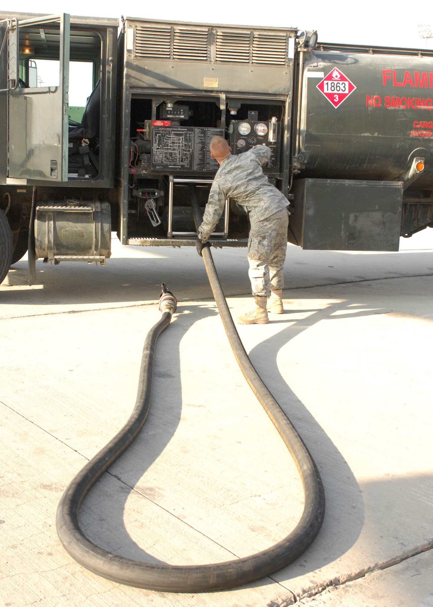 BAGRAM AIRFIELD, Afghanistan -- Senior Airman Jacob Barnes, a fuels journeyman from the 455th Expeditionary Logistics Readiness Squadron, drags a hose back to his truck after fueling a C-17 Globemaster III waiting to load cargo for troops in the field, Nov. 17, 2009. Airman Barnes is from Detroit, Mich., and is deployed from Andersen Air Force Base, Guam. (U.S. Air Force photo/Senior Airman Susan Tracy)
