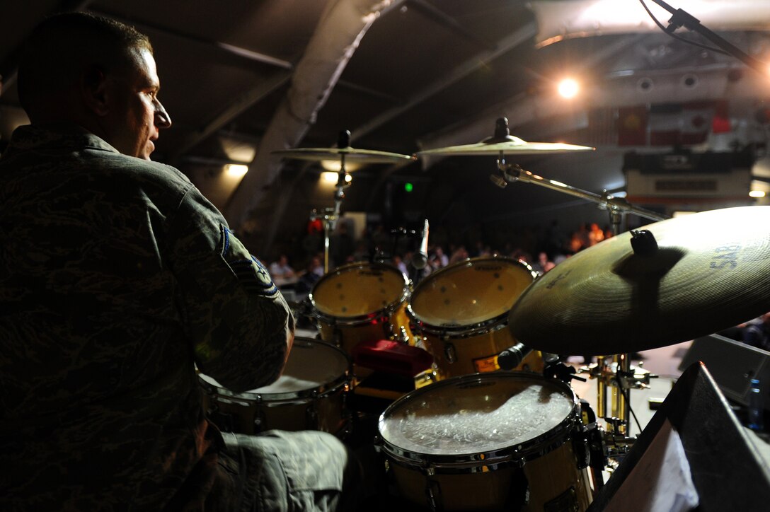 TRANSIT CENTER AT MANAS, Kyrgyzstan -- Master Sgt. Anthony DeLuzio, U.S. Air Forces Central Sirocco Band drummer, keeps the beat during a performance at Pete's Place, Nov. 15, 2009. The Sirocco Band is stationed at a base in Southwest Asia and is deployed from Lackland Air Force Base, Texas. (U.S. Air Force photo/Senior Airman Steele C. G. Britton)