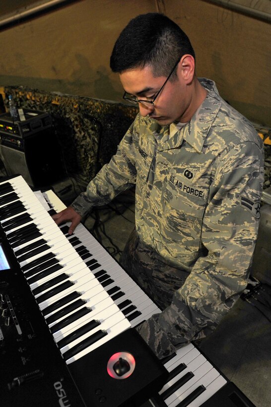 TRANSIT CENTER AT MANAS, Kyrgyzstan -- Airman 1st Class Dennis Lambert, U.S. Air Forces Central Sirocco Band pianist, plays the keys during a performance at Pete's Place, Nov. 15, 2009. The Sirocco Band is stationed at a base in Southwest Asia and is deployed from Lackland Air Force Base, Texas. (U.S. Air Force photo/Senior Airman Steele C. G. Britton)