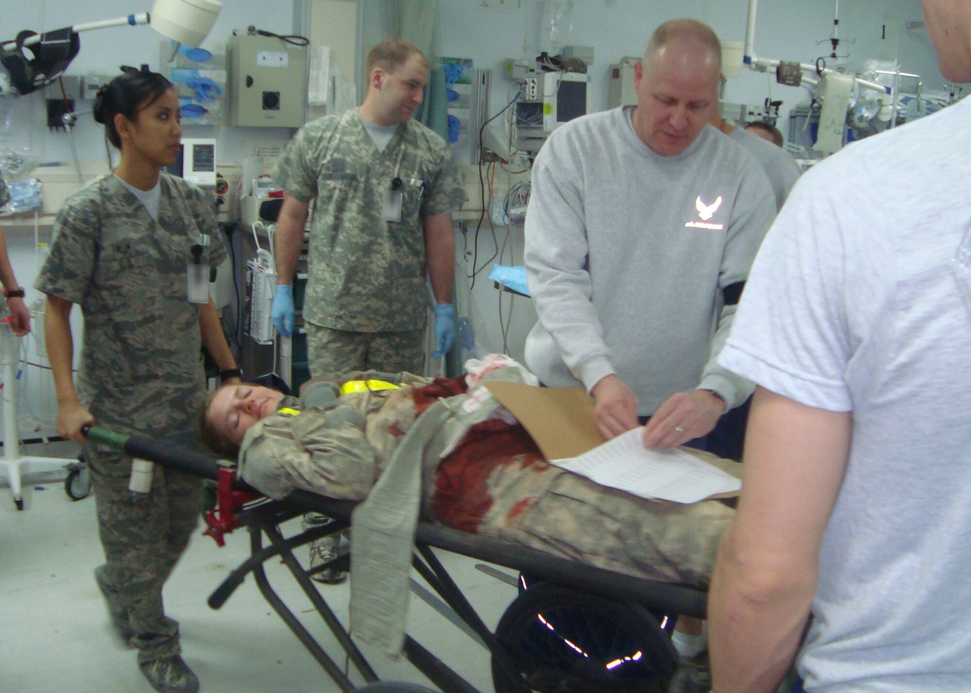 BAGRAM AIRFIELD, Afghanistan -- Airmen and Soldiers at the Craig Joint Theater Hospital tend to a simulated “victim” during a mass-casualty exercise here Nov 13, 2009.  Airmen and Soldiers found the exercise useful as just days later an insurgent rocket attack on a civilian marketplace in the Tagab Valley wounded many civilians.  Thirteen Afghan civilians, many children and elderly men, were medically evacuated to Bagram’s hospital where Airmen put the exercise skills to use in the real-life scenario.  (U.S. Air Force photo/Capt. James McDaniel)