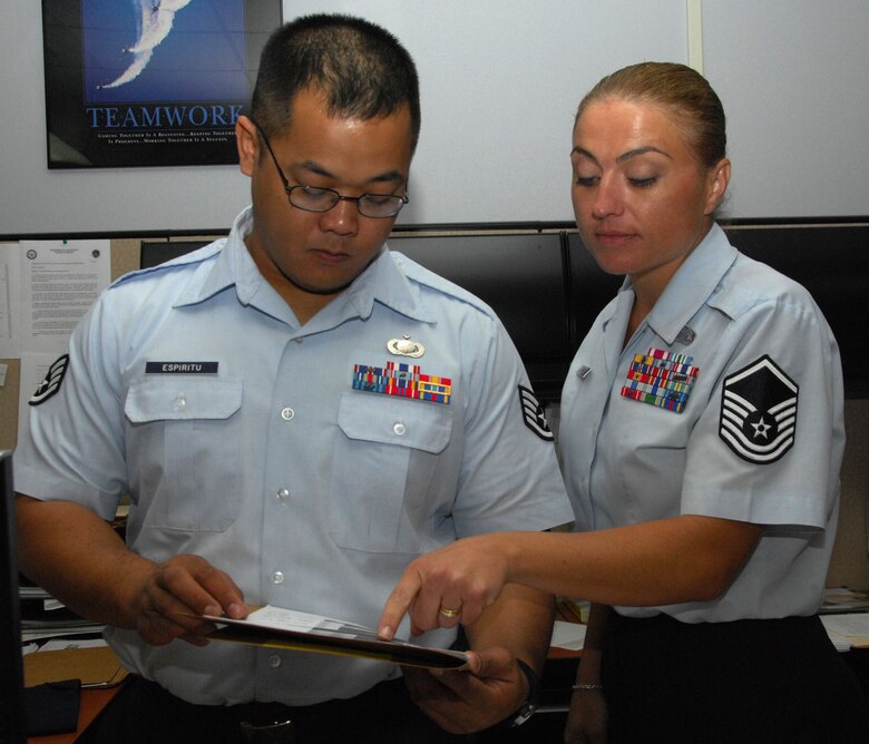 ANDERSEN AIR FORCE BASE, Guam - Staff Sgt. Adrian Espiritu, 36th Comptroller Squadron, receives guidance from Master Sgt. Pam Binnie, 36th CPTS chief of financial services, for a travel voucher Nov. 16. Sergeant Binnie's expert leadership netted her a selection as 'Top Performer' from her unit's first sergeant. (U.S. Air Force photo by Senior Airman Shane Dunaway)