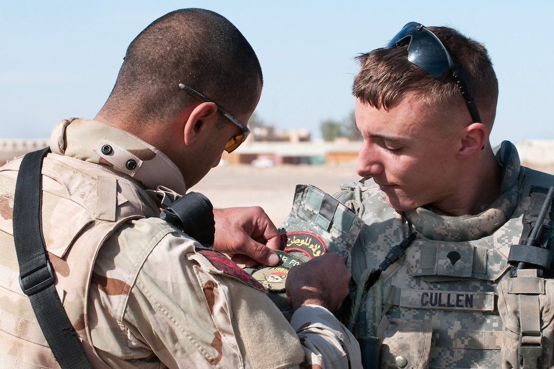 An Iraqi commando, Ahmed, and U.S. Army Spc. Patrick Cullen trade unit patches during joint air assault training for U.S. Army paratroopers and Iraqi commandos and scouts on Camp Ramadi, Iraq, Nov. 15, 2009. During the exercise, Iraqi and American soldiers inspected equipment, discussed warfighting techniques and traded uniform patches. Cullen is assigned to the 82nd Airborne Division's 2nd Battalion, 504th Parachute Infantry Regiment, which is serving as an Advise and Assist Brigade.