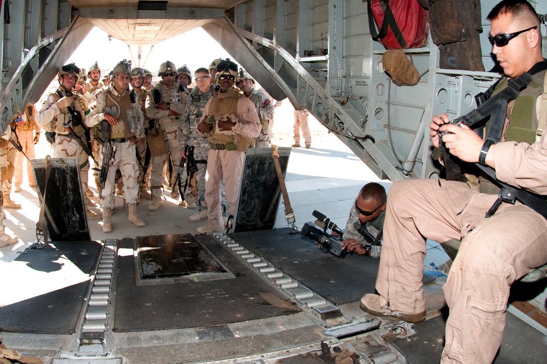 U.S. Marine Corps Staff Sgt. Terrance Clark demonstrates to U.S. Army paratroopers and Iraqi commandos and scouts how to properly adjust a seatbelt aboard a helicopter during joint air assault training on Camp Ramadi, Iraq, Nov. 15, 2009. Clark is a crew chief assigned to Heavy Marine Helicopter 462. The U.S. soldiers are assigned to the 82nd Airborne Division's 2nd Battalion, 504th Parachute Infantry Regiment, which is serving as an Advise and Assist Brigade. The training is designed to prepare troops for possible joint missions in Al Anbar province, where the units chiefly operate. 