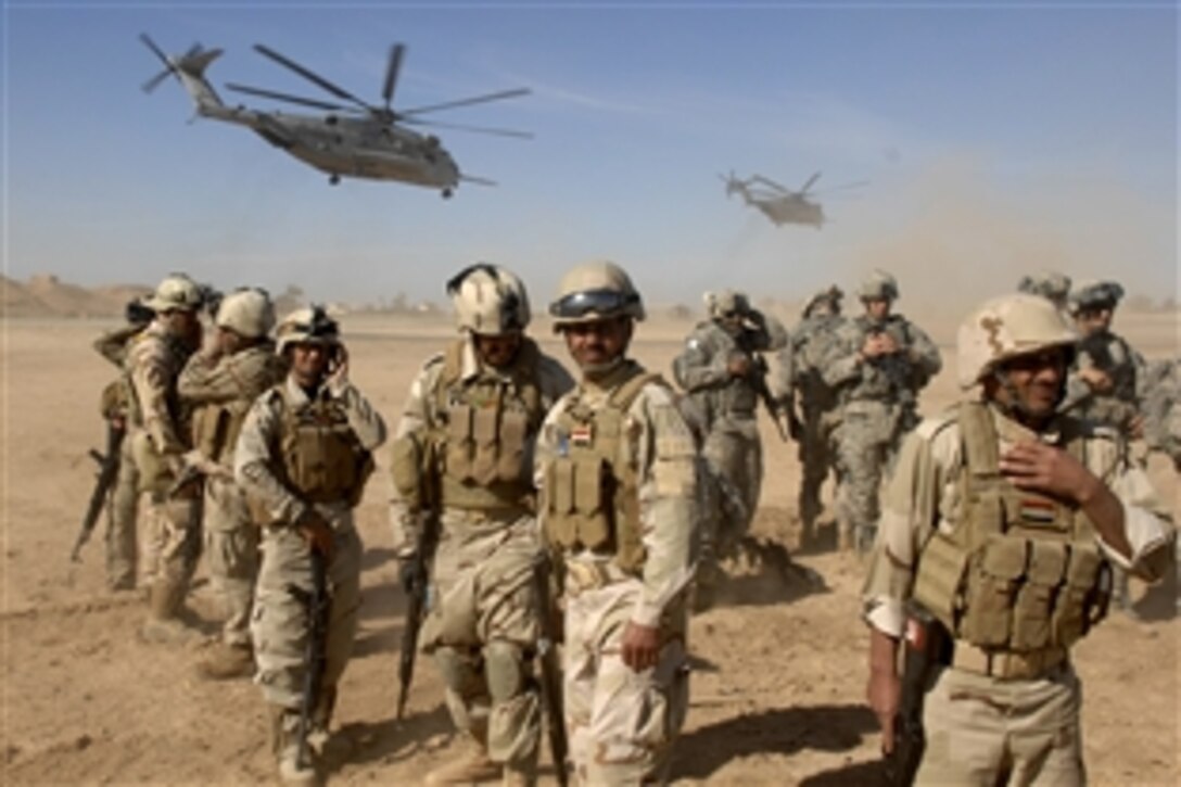 U.S. soldiers shield themselves from sand and rocks kicked up by a CH-53 Sea Stallion during a static loading exercise at Camp Ramadi, in western Iraq, Nov. 15, 2009. The soldiers are assigned to the 1st Iraqi Army and U.S. 82nd Airborne Division's 2nd Battalion, 504th Parachute Infantry Regiment, 1st Brigade Combat Team.