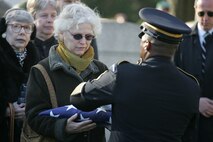NEW YORK -- An Army soldier presents an American Flag to Debra Allee, the niece of the formerly oldest living female Marine, Miriam Cohen, who was buried Nov. 17, in Cypress Hills National Cemetery in honor of Cohen's service to her country. The 101-year-old Cohen enlisted in the Marine Corps during World War II and again during the Korean War. She was the oldest female enlistee of her time at 35 years old and was part of the first female Marine recruit class. (Official Marine Corps photo by Sgt. Randall A. Clinton)