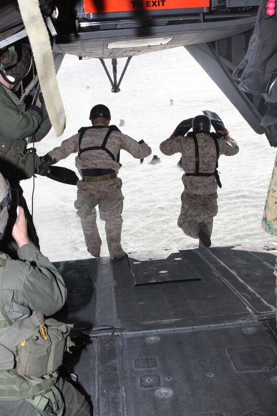 Two Marines with the Basic Reconnaissance Course, School of Infantry West, dive out of a CH-53E "Super Stallion," during helocast training Nov. 17. The students jumped ten feet from the water's surface aboard a CH-53E belonging to Marine Heavy Helicopter Squadron 361.