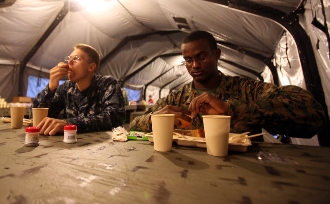 Seaman Apprentice Enns U. Paul and Seaman Recruit Jesse B. Kiepper, religious programs specialist with 2nd Marine Logistics Group, enjoy a meal made with the Expeditionary Feeding Kitchen aboard Camp Lejeune, N.C., November 19, 2009. The kitchen produced 1,500 meals a day that were served to warfighters from all around the installation.