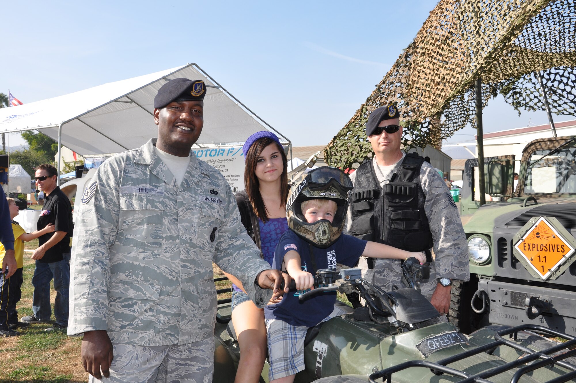 Tech. Sgt. Warman and Tech. Sgt. Hill show security forces equipment to two young visitors who attended the veteran’s celebration at Flabob Airport in Riverside Nov. 7.  Staff Sgt. Hardy, Tech. Sgt. Warman, Tech. Sgt. Hill and Tech. Sgt. House volunteered to bring equipment from March to display at the event, which honored all veterans, from all wars, in all services. (U.S. Air Force photo by Capt. Mary Guest)