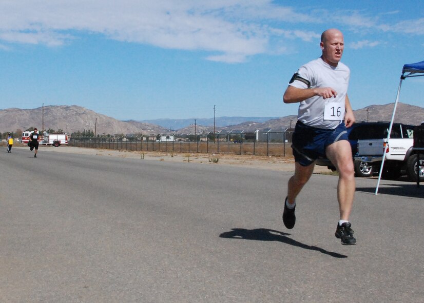 Second place finisher Tech. Sgt. Duane Bogart sprints to the finish line of the Jive Turkey 5K race Nov. 4.  Third place finisher Staff Sgt. Robert Huerta races to catch up, finishing just 10 seconds behind Sergeant Bogart. (U.S. Air Force photo)