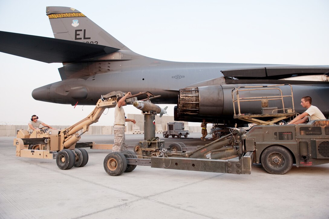 Airmen 1st Class Michael Huber (from left), Phillip Rhinehart and Matthew Beard load GBU-38s onto a B-1B Lancer Nov. 11, 2009, at an air base in Southwest Asia. The Airmen are deployed with the aircraft from Ellsworth Air Force Base, S.D., in support of operations Iraqi Freedom and Enduring Freedom. (U.S. Air Force photo/Staff Sgt. Robert Barney)