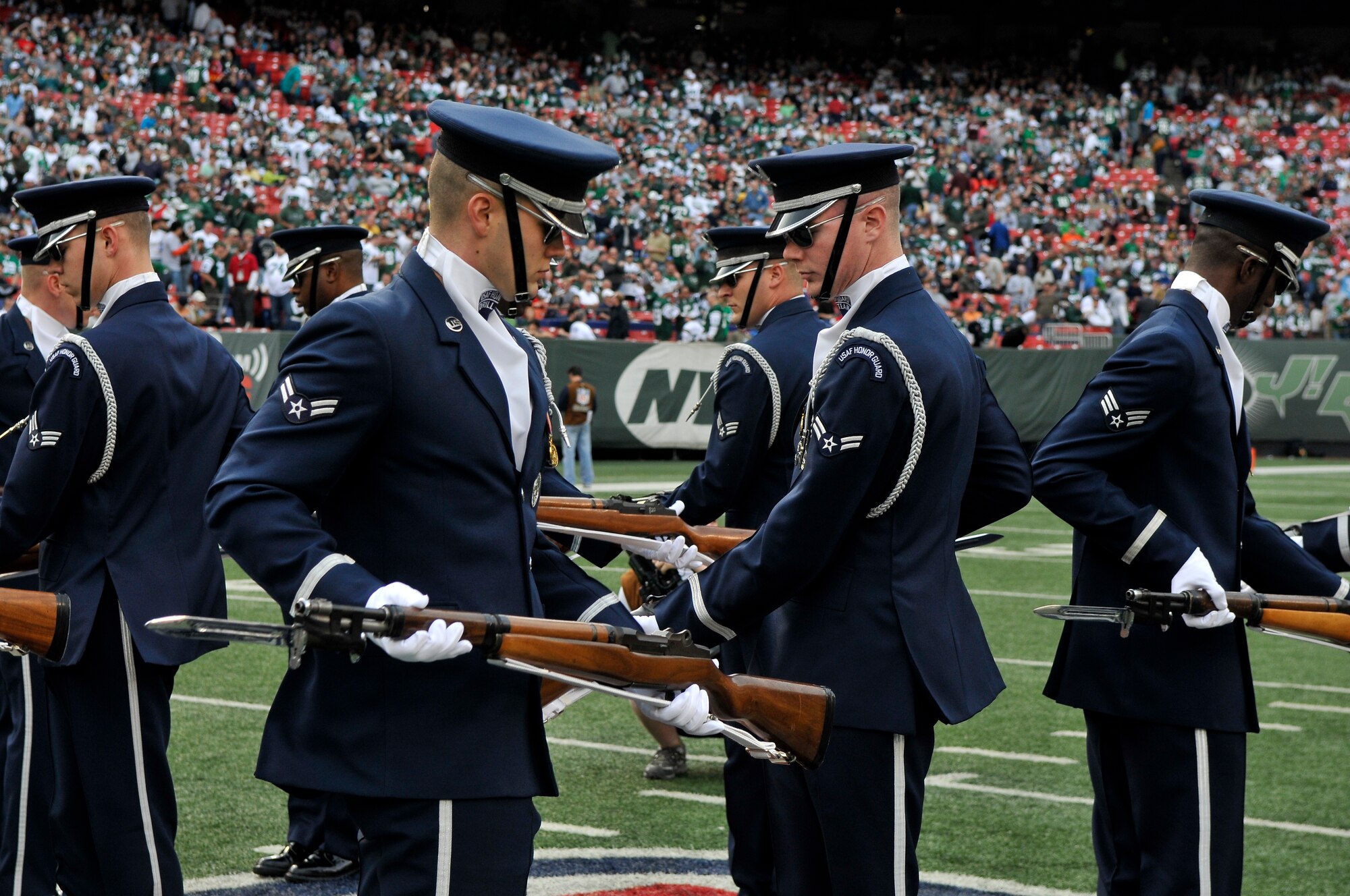 Airmen 1st Class Michael Courtright and Andrew Winders, United States Air Force Honor Guard Drill Team, simultaneously perform during the halftime show at a New York Jets football game against the Jacksonville Jaguars at Giants Stadium Nov. 15, in East Rutherford, New Jersey. The Drill Team tours worldwide to showcase Air Force precision and professionalism. During the Air Force Honor Guard's 60-year history, their traveling component, the Drill Team, has performed in every state of the union and many countries abroad. (U.S. Air Force photo/Senior Airman Marleah Miller)