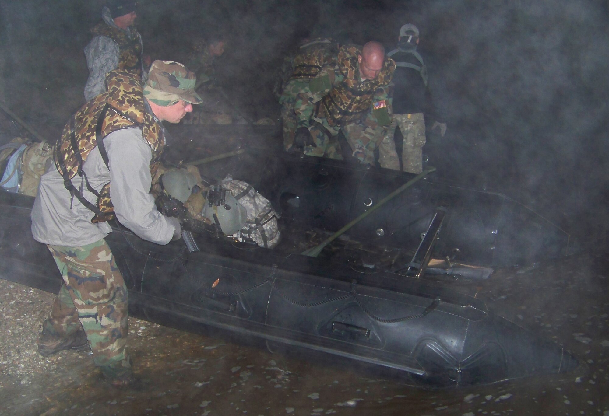 Tech. Sgt. Jason Rushing (left) and Tech. Sgt. Charles Smith (center), both combat aviation advisors with the 19th Special Operations Squadron, prepare a row boat for travel during the Raven Claw field exercise at the Eglin range Nov. 5. The boats were used during part of a 20-mile expedition across the Eglin range at night. (Air Force photo by Airman 1st Class Joe McFadden.)