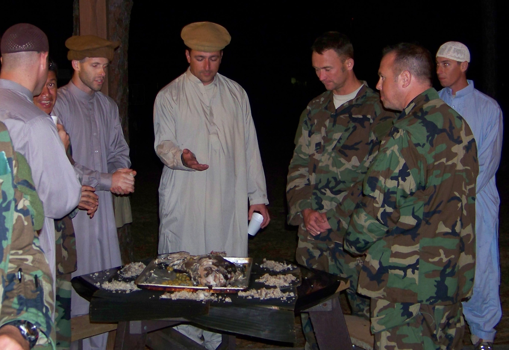 Capt. Kevin Fischer and Tech. Sgt. Timothy Dodge, both combat aviation advisors with the 19th Special Operations Squadron, are presented with a meal of fish heads, tripe, water beetles and salted crickets by indigenous forces during the Raven Claw field exercise at the Eglin range Nov. 4. Airmen stomached the meal to not offend their partners who considered the food a luxury.    (Air Force photo by Airman 1st Class Joe McFadden.)