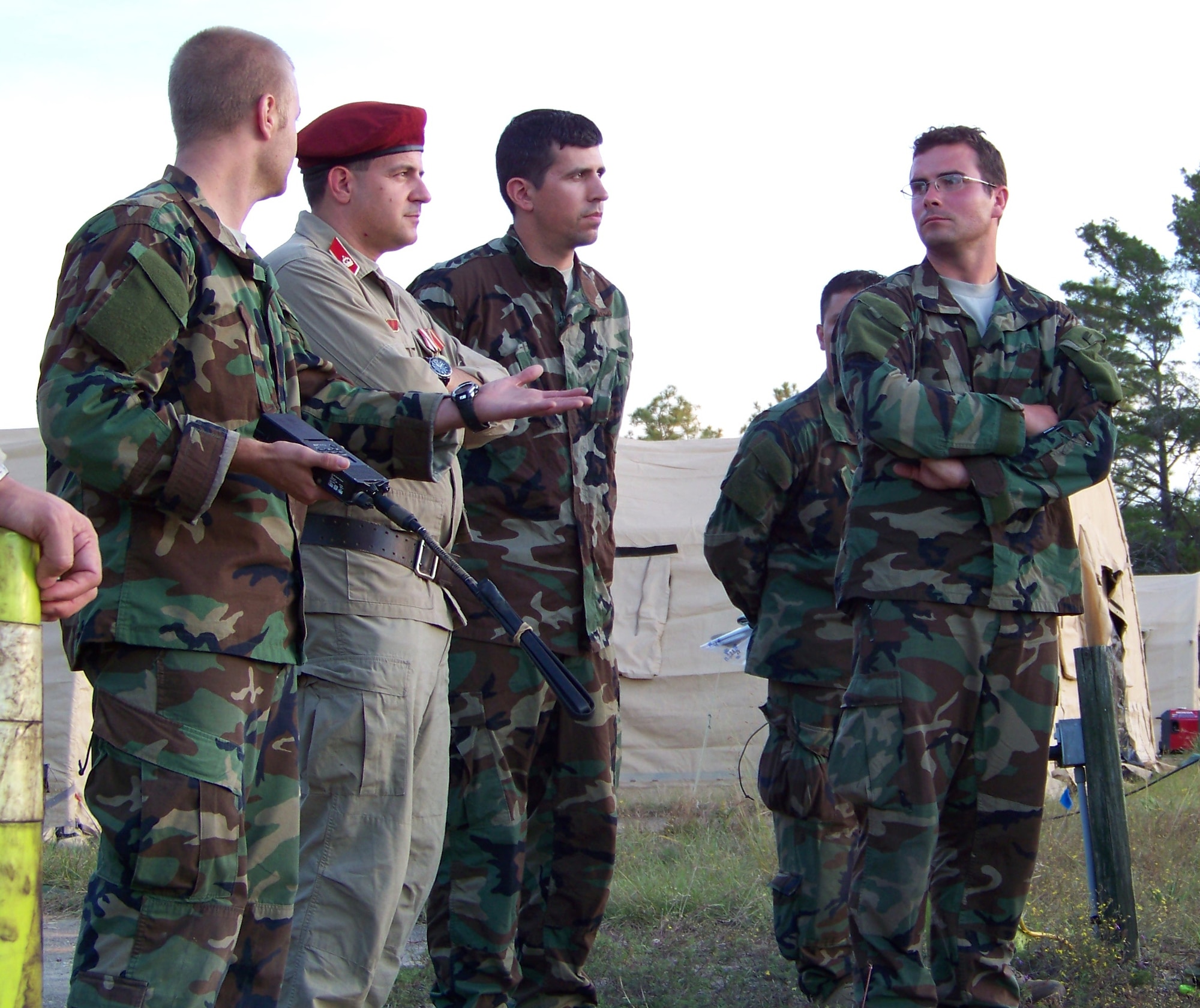 Staff Sgt. Sean Tanner (left), a combat aviation advisor with the 19th Special Operations Squadron, explains the joint personnel recovery rehearsal being conducted by a joint combat aviation advisor and indigenous force recovery team to the partner nation’s high commander during the Raven Claw field exercise at the Eglin range Nov. 3. Fellow advisors Maj. David Bruton (center) and Capt. Brian Daniels (right) also led the partner nation commanders on a tour of the encampment. (Air Force photo by Airman 1st Class Joe McFadden.)