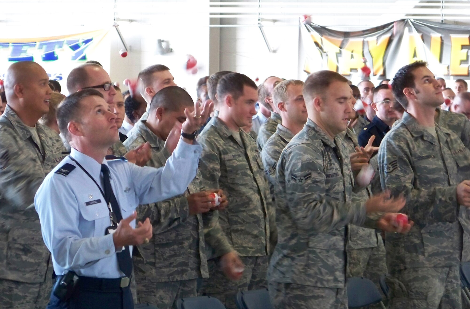 Col. Greg Lengyel, 1st Special Operations Wing commander, juggles three balls along with Airmen during a Wingman Day briefing at Freedom Hangar Nov. 16. Colonel Lengyel later presented a specialized 105mm trophy to Curtis Zimmerman in appreciation for Mr. Zimmerman’s motivational presentation. (Air Force photo by Airman 1st Class Joe McFadden.)