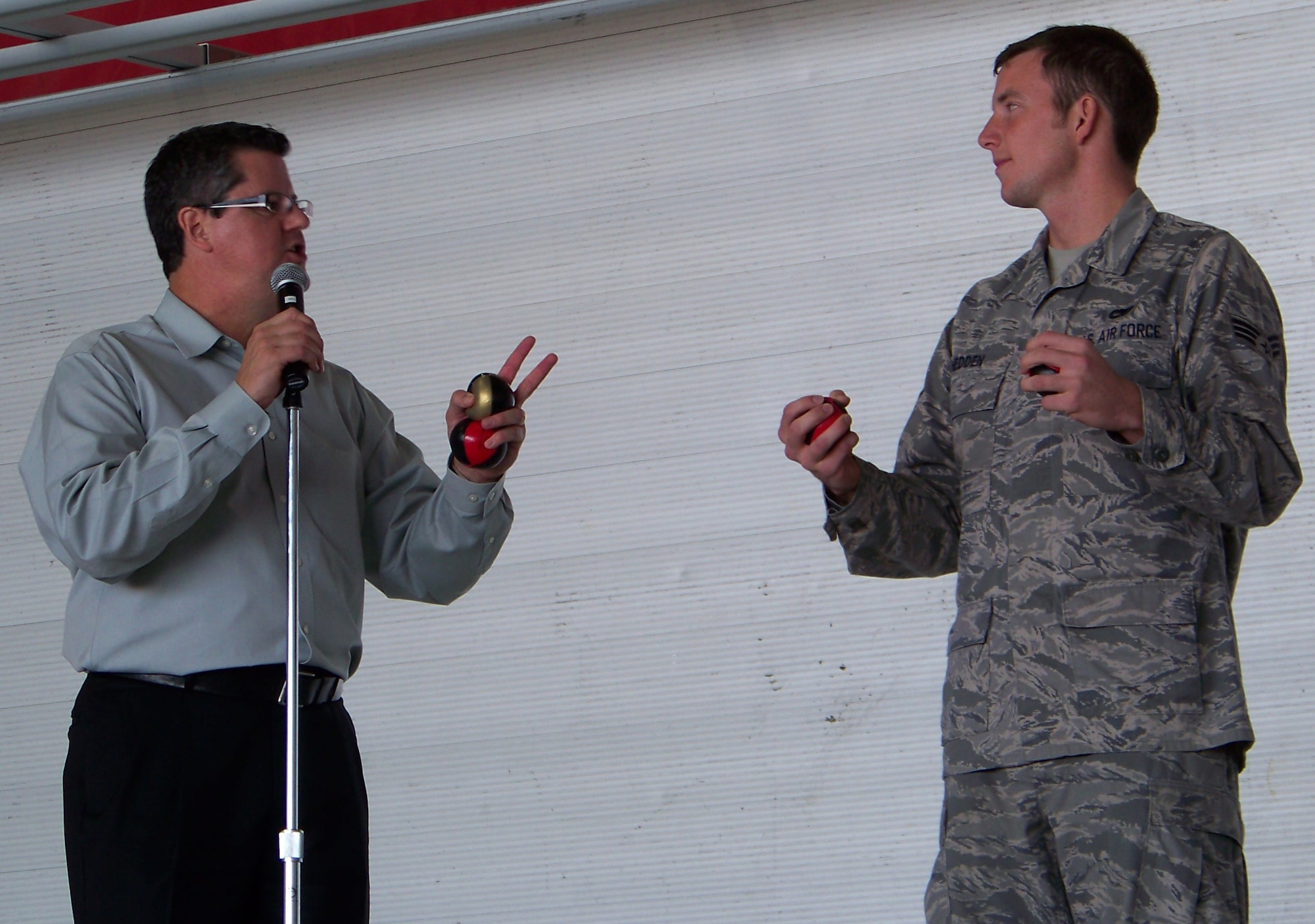 Curtis Zimmerman tries to convince Senior Airman Joshua Hedden, 1st Special Operations Maintenance Squadron, that he can juggle three balls during a Wingman Day briefing at Freedom Hangar Nov. 16. Airman Hedden later successfully juggled the balls eight times. (Air Force photo by Airman 1st Class Joe McFadden.)