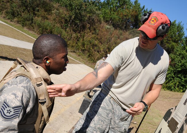 Staff Sgt. John Foster instructs Tech. Sgt Jonell McFadden on how to improve his technique during weapons qualification training at the Naval Weapons Station Charleston Nov. 16. Combat arms training is one of 26 courses the students must complete during Expeditionary Combat Skills Training. Sergeant Foster is a combat arms instructor with the 437th Security Forces Squadron and Sergeant McFadden is a passenger service training manager with the 437th Aerial Port Squadron. (U.S. Air Force photo/Senior Airman Katie Gieratz)(RELEASED)