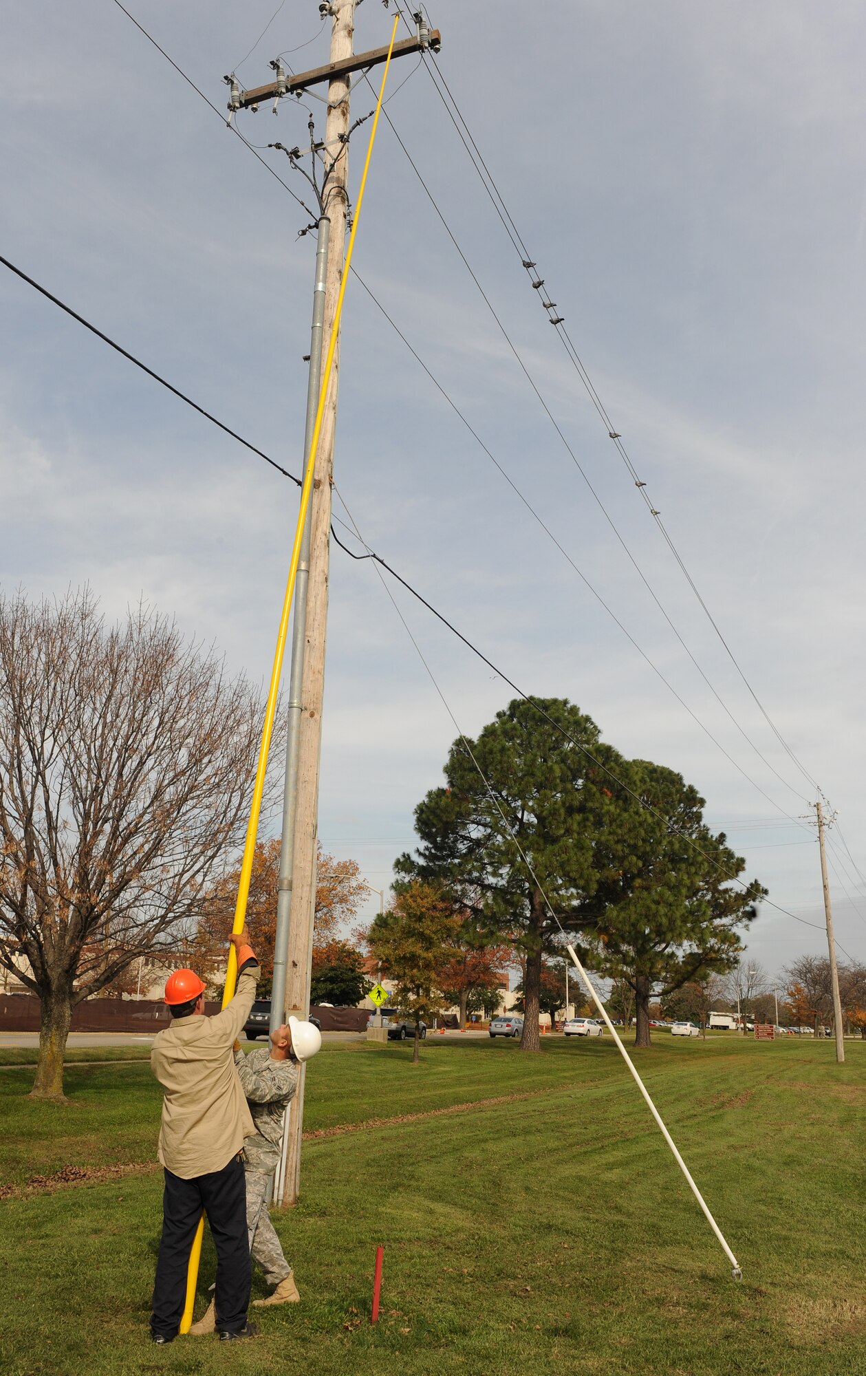 LANGLEY AIR FORCE BASE, Va. --  Rick Minks and Airman 1st Class Welmer Reyes, 1st Civil Engineer Squadron Electrical Systems technicians, replace blown fuses on a power line Nov. 17.  Last week, a nor'easter struck Langley and damaged power lines.  (U.S. Air Force photo/Senior Airman Zachary Wolf)