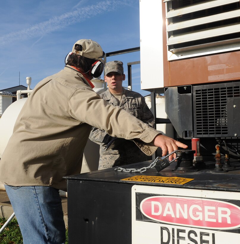 LANGLEY AIR FORCE BASE, Va. --  Don Paramore and Airman 1st Class Adam Torres, 1st Civil Engineer Squadron Power Production Maintenance mechanic, check the fuel level on a generator Nov. 17.  The generator powers flight line lights and requires and inspection because a nor'easter flooded Langley last week.  (U.S. Air Force photo/Senior Airman Zachary Wolf) 