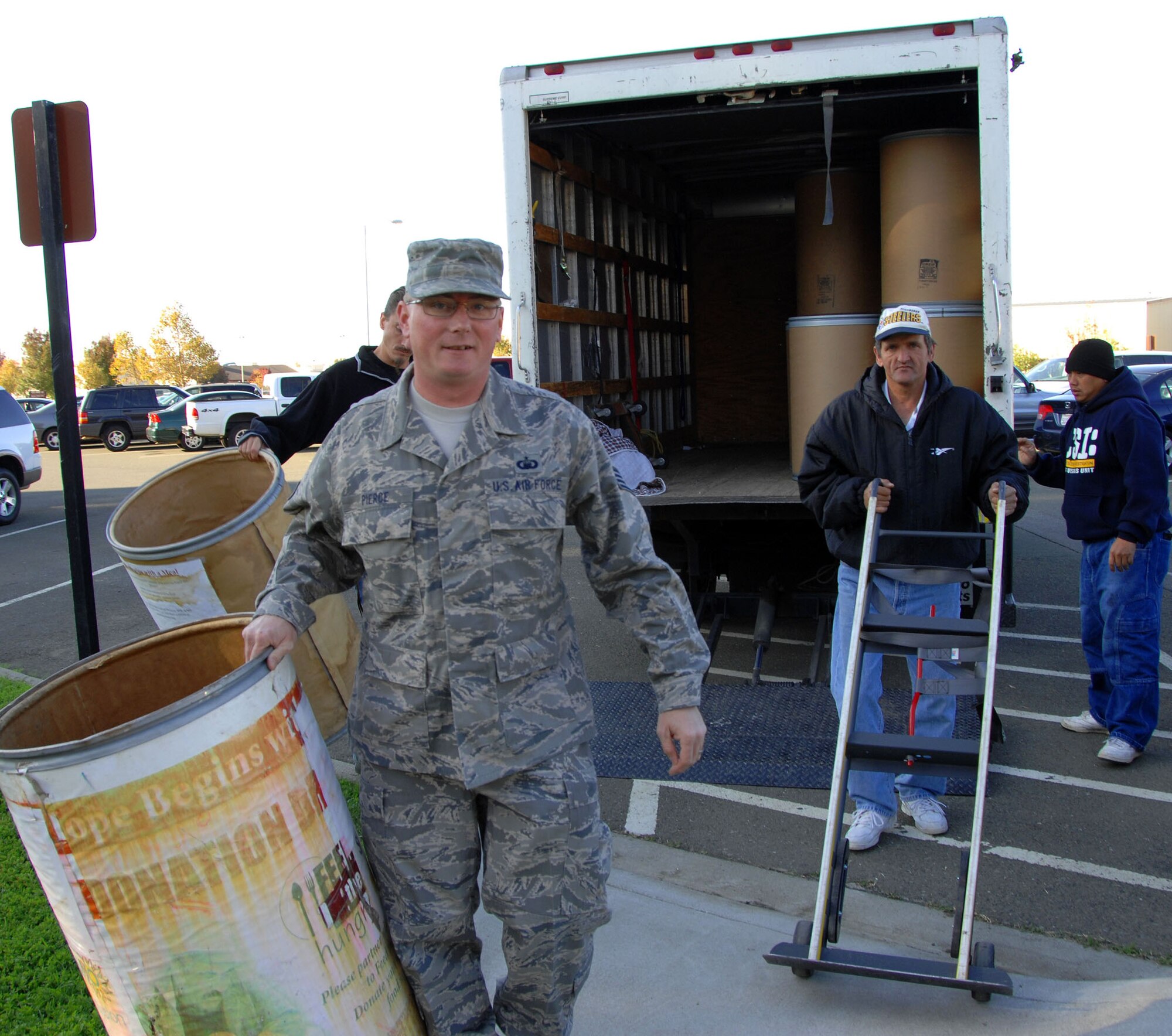 TRAVIS AIR FORCE BASE, Calif.--Staff Sgt. Michael Pierce, 349th Air Mobility Wing chaplain assistant, carries large barrels off the back of a truck to fill with donated food. Sergeant Pierce and the chaplain staff spearhead a yearly food drive that support local charities that feed the hungry and homeless. A friendly competition between the wing squadrons ensues, as each group tries to donate the most pounds of food and win the competition. The gauntlet has been thrown down by the 349th Maintenance Group! Food collection will continue throughout the holiday season. (U.S. Air Force photo/SMSgt. Ellen L. Hatfield)