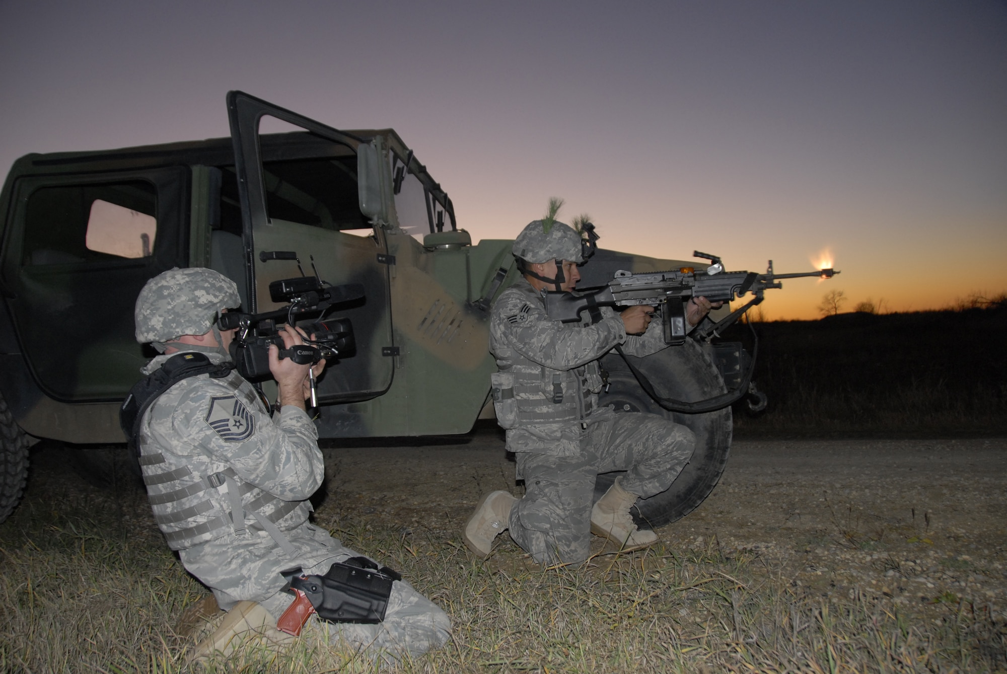 Master Sgt. Dan Richardson (left), broadcaster with the 115th Fighter Wing in Madison, Wis., videotapes as Senior Airmen Nathan Ortiz engages in a firefight during a Security Forces exercise at Volk Field Combat Readiness Training Center Nov. 7, 2009. Three public affairs personnel from the 115th embedded with SF to learn how to effectively operate under the pressures of a combat environment.  The training proved beneficial to both sides as SF members learned ways to protect embedded assets while performing their regular duties.  (U.S. Air Force Photo by Tech. Sgt. Don Nelson)