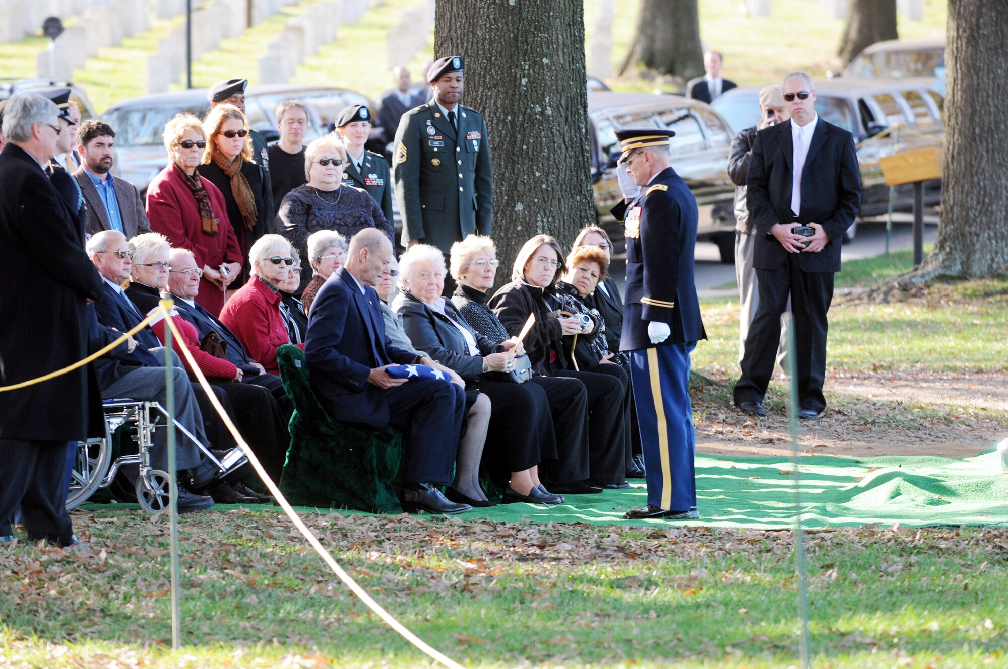 A high ranking military official salutes a family member after presenting the American flag at an internment ceremony for seven members of the  World War II B-25 aircrew that were lost Dec. 5, 1942, near Papua, New Guinea, at Arlington National Cemetery in Virginia Nov. 17, 2009. (Defense Department photo/Navy Petty Officer William Selby)