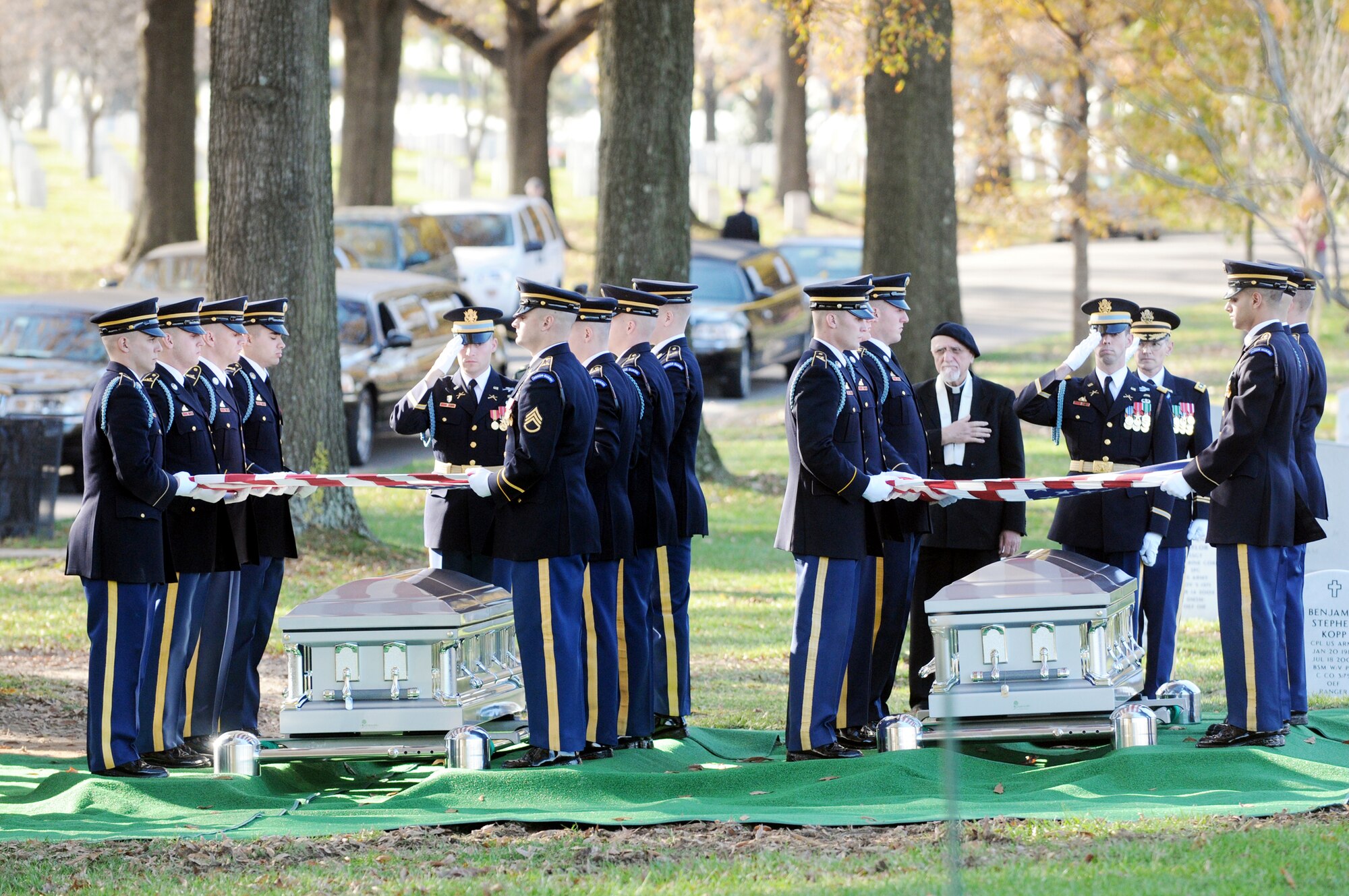 Two high ranking military members render a salute as the honor guard prepare the flags to present to family members of members of the World War II B-25 crew that was lost Dec. 5, 1942 near Papua, New Guinea, at an interment ceremony at Arlington National Cemetery in Virginia. (Defense Department photo/Navy Petty Officer William Selby)