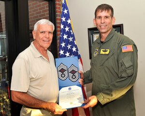 Retired Chief Master Sgt. Ronald Fox presented his son, Senior Master Sgt. Damian Fox with his new set of stripes after his recent promotion to Chief Master Sergeant. Sergeant Fox will sew on his stripes in the spring of 2010. Sergeant Fox is a assigned to the 437th Operations Group. (U.S. Air Force photo/James Bowman) 