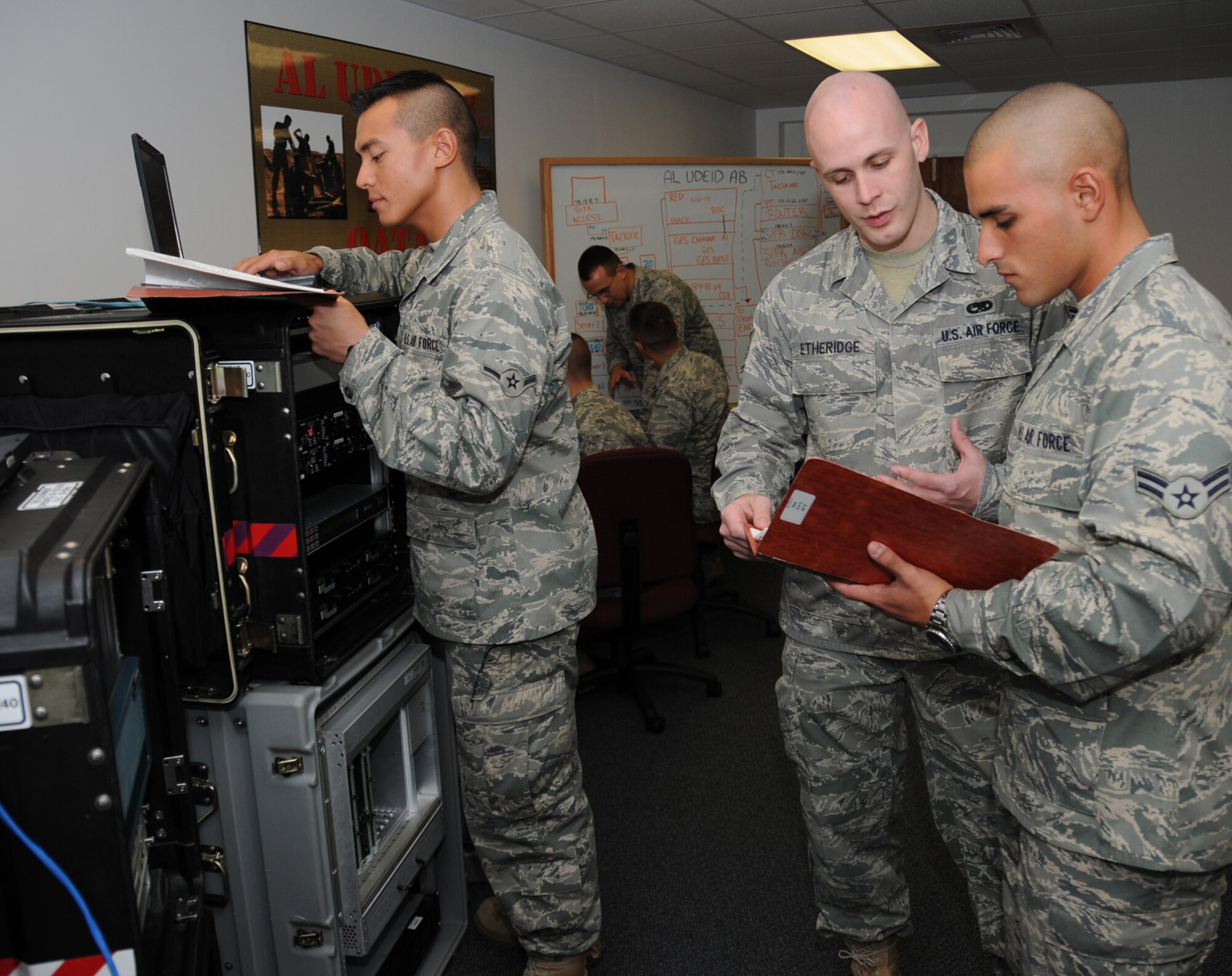 Staff Sgt. Patrick Etheridge, center, 338th TRS instructor, trains Airman Alexander Grilho, left, and Airman 1st Class Emilio Dominguez on equipment known as a theatre deployable communications/integrated communications access package.  In the background, Tech Sgt. Wayne Mangiardi instructs Airman 1st Class Sam Bessinger and Airman Michael Nichols on server configuration.  (U.S. Air Force photo by Kemberly Groue)