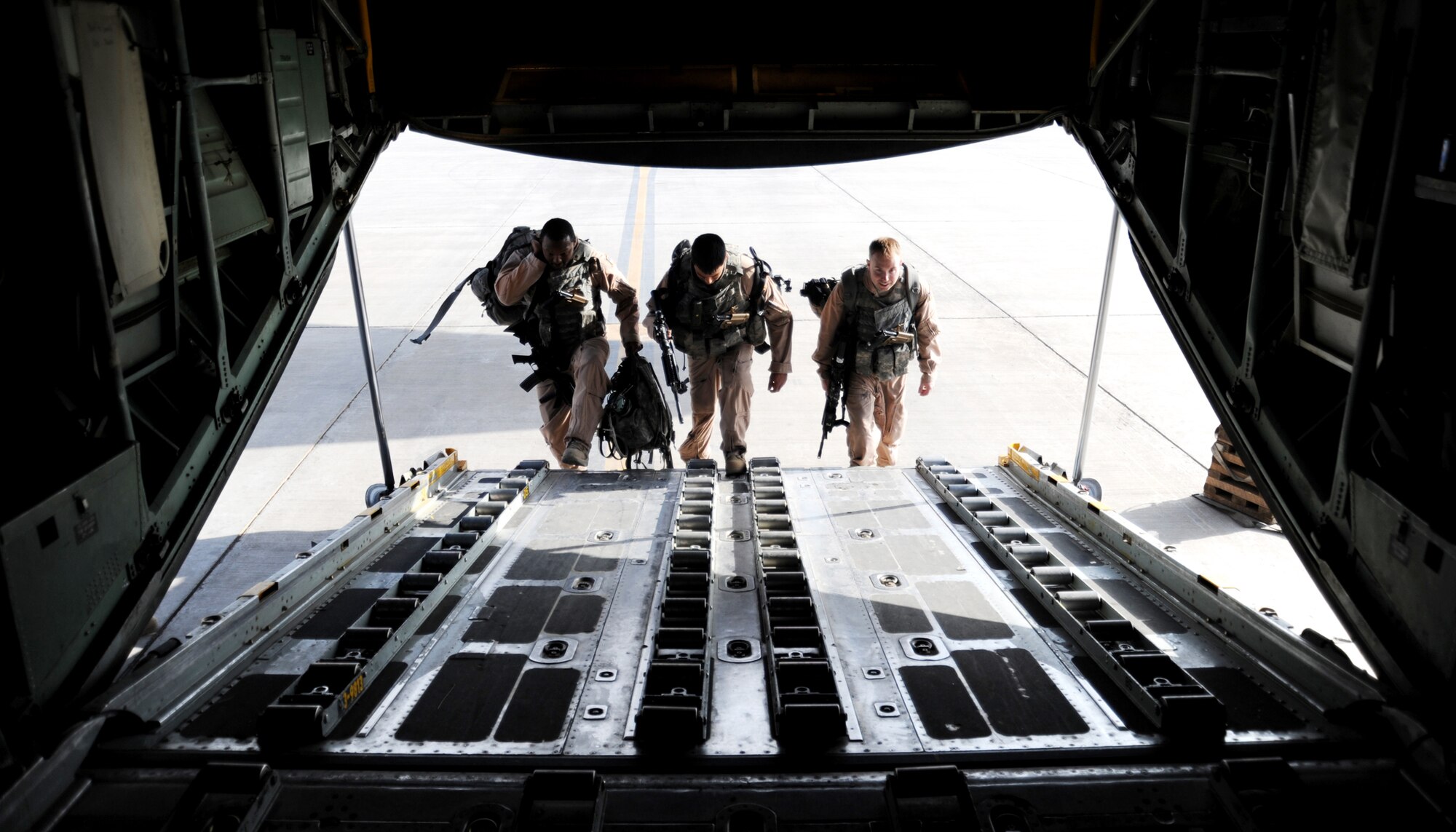 JOINT BASE BALAD, Iraq -- Staff Sgt. Rafeal Strother, Staff Sgt. Chris Amor and Senior Airman Bryan Malia, 332nd Expeditionary Security Forces Squadron fly-away security team members, board a C-130 Hercules prior to departure on a mission Nov. 13, 2009. The FAS team provides ground security, resources and crewmembers to neutralize possible threats to U.S. aircraft at airfields throughout the area of responsibility. (U.S. Air Force photo/Senior Airman Christopher Hubenthal)