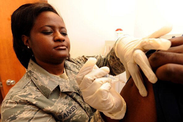 SHAW AIR FORCE BASE, S.C. -- Technical Sgt. Tracy Sankey, 20th Medical Support Squadron, Immunization Clinic NCO-in-charge , gives the H1N1 shot to Michael Conyers, 20th Medical Support Squadron medical technician, Nov 18. (U.S. Air Force Photo/Senior Airman David Minor)