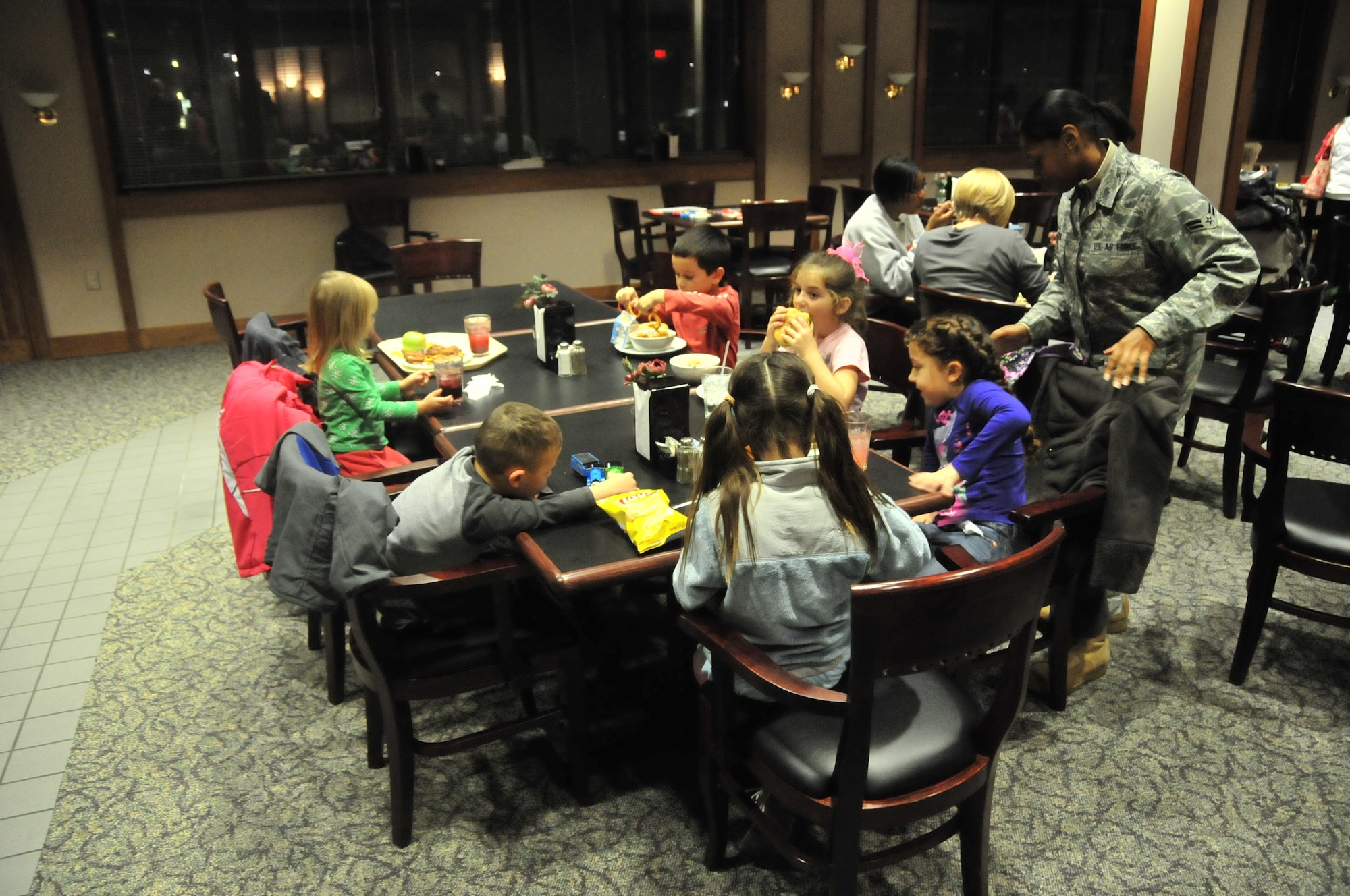 Airman 1st Class Marissa Tucker, EAGLES Council public affairs officer, helps 6-year-old Madison Ryther, with her meal during a Yellow Ribbon dinner at the Seymour Johnson Air Force Base Southern Eagle Dining Hall, Nov. 12, 2009. Madison is the daughter of Teresa and Lt. Col. Joseph Ryther, 335th Fighter Squadron commander. During the dinner members of the EAGLES Council, a professional organization for Airmen E-1 through E-4, offer assistance carrying trays, holding little ones or watching children while their parents get food. (U.S. Air Force photo/Tech. Sgt. Lesley Waters)