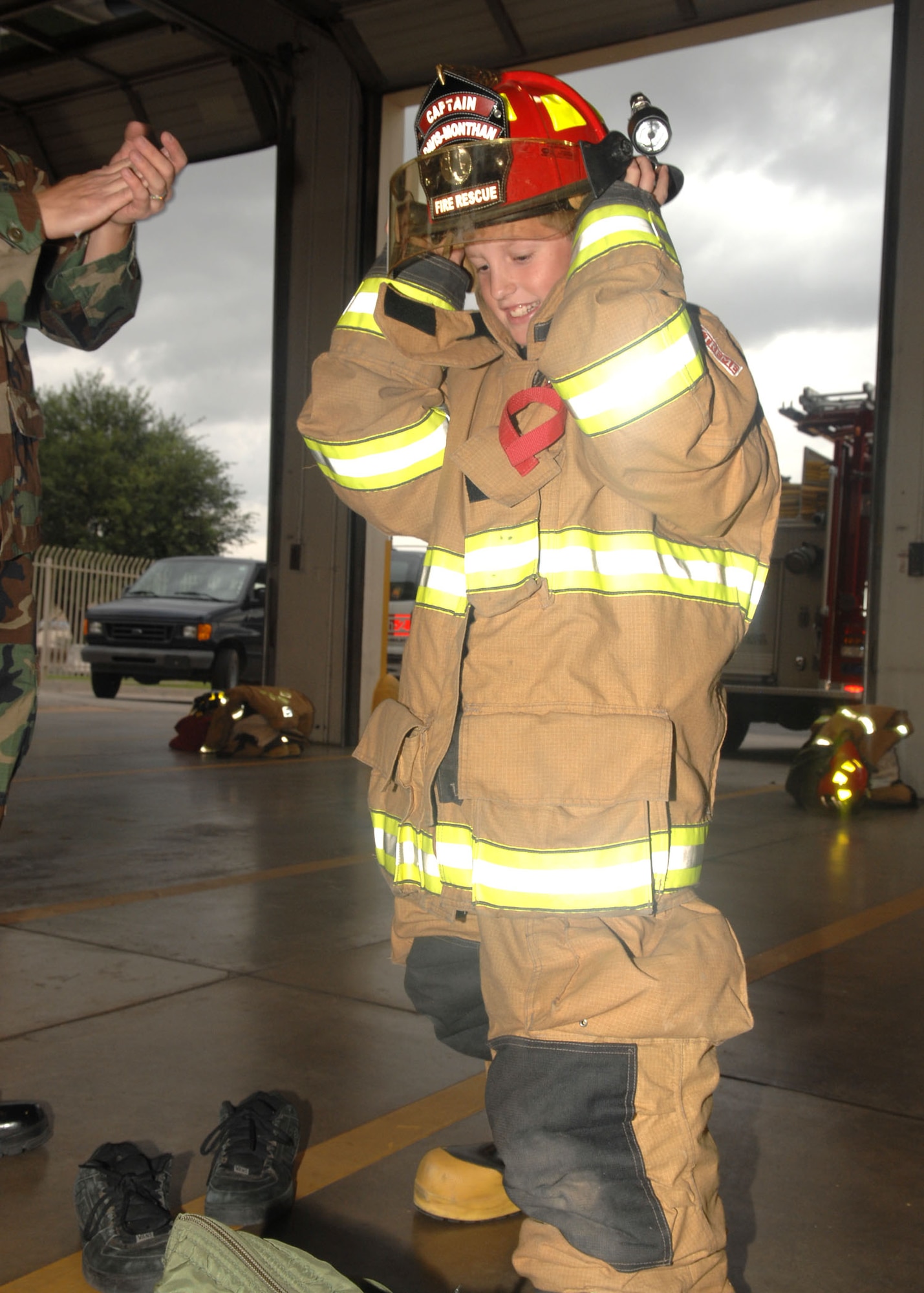 During a tour of the Davis-Monthan fire station, Pilot for a Day participant, Jake McKay, experienced what it was like to wear firefighter gear Nov. 13. The firemen challenged Jake to suit up in less than one minute as required for all firefighters. As part of his tour he also went to the control tower and the 358th Fighter Squadron. (U.S. Air Force photo/Airman Jerilyn Quintanilla)
