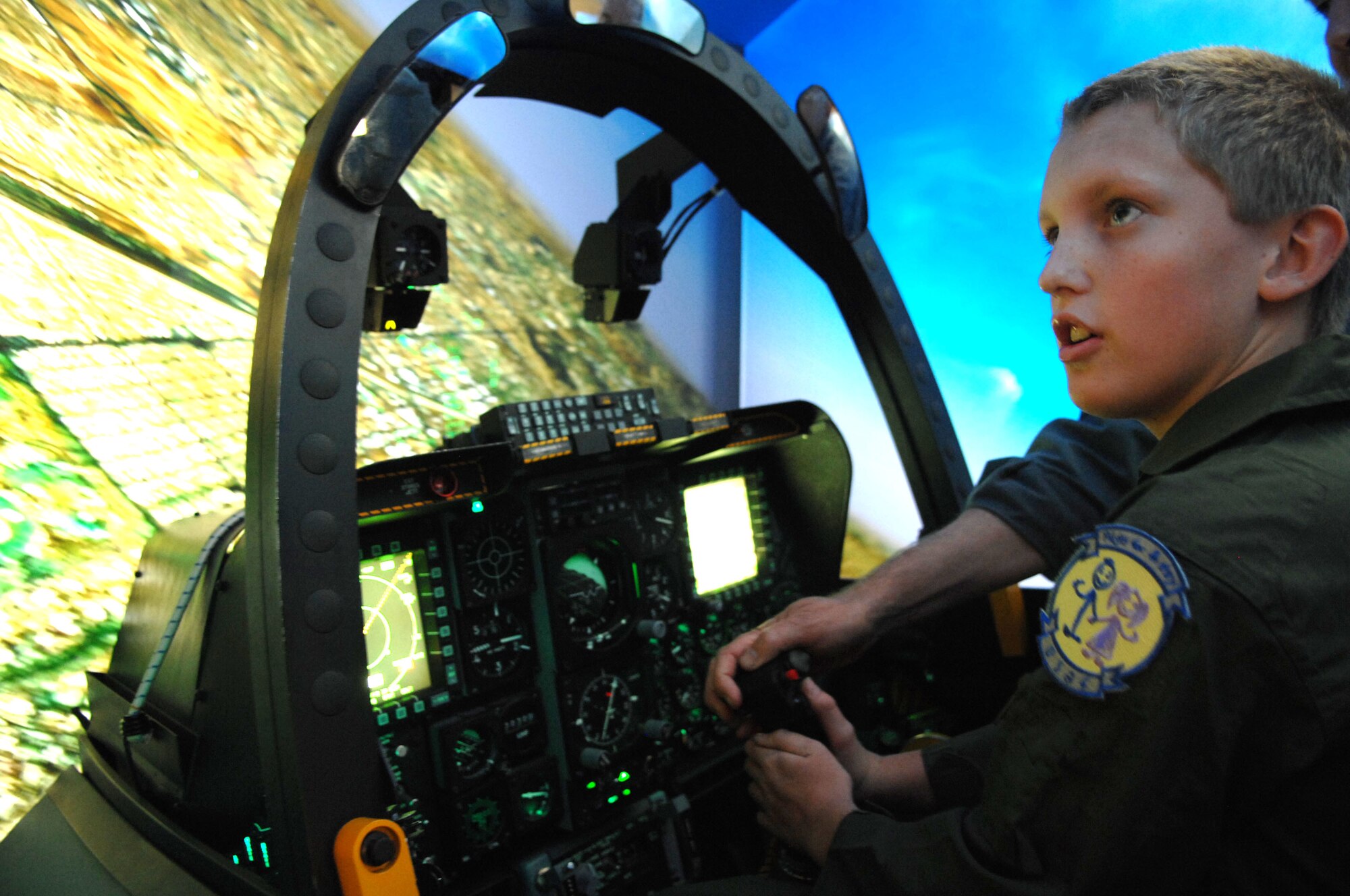 Pilot for a Day participant Jake McKay experiences an A-10 simulator at the 355th Operations Support Squadron Nov. 13. The simulator replicates flying an aircraft over a virtual map as realistically as possible. As part of the program, Jake and his family were provided with a tour of the base, which included the chance to see the A-10 Thunderbolt, an HC-130 Hercules and a HH-60 Pavehawk. This program benefits children of the Tucson community battling catastrophic illnesses. (U.S. Air Force photo/Airman Jerilyn Quintanilla)
