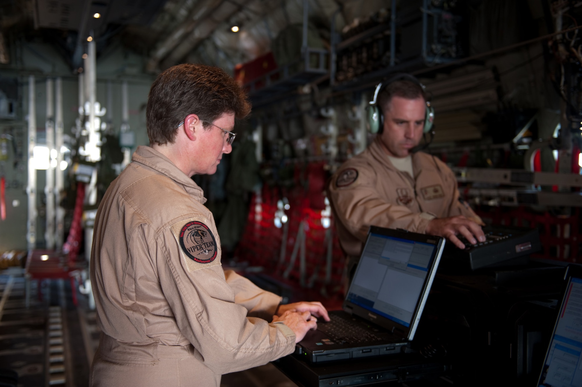 Right, Master Sgts. Bryan Doyea and Juli Croft, 379th Expeditionary Communications Squadron Viper Team members, set up and prepare a Viper communications package aboard a C-130 Hercules, Nov. 16, 2009, in Southwest Asia. The Viper team provides secure and non-secure communications aboard aircraft for top officials traveling throughout the U.S. Central Command area of responsibility in support of operations Iraqi Freedom and Enduring Freedom. (U.S. Air Force photo/Staff Sgt. Robert Barney) 