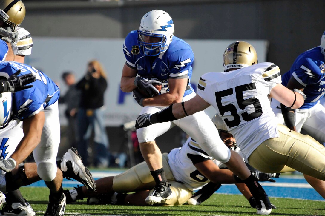 AIR FORCE ACADEMY, C.O..-- Falcons running back Jared Tew rushes pass Black Knights defenders during the Army versus Air Force game, Nov. 7. Tew, a junior and native of Park City, Utah, had his second 100-yard game of the season with 102 yards on 25 carries in the Air Force’s Falcons 35-7 victory. (U.S. Air Force photo/Airman 1st Class Corey Hook)

