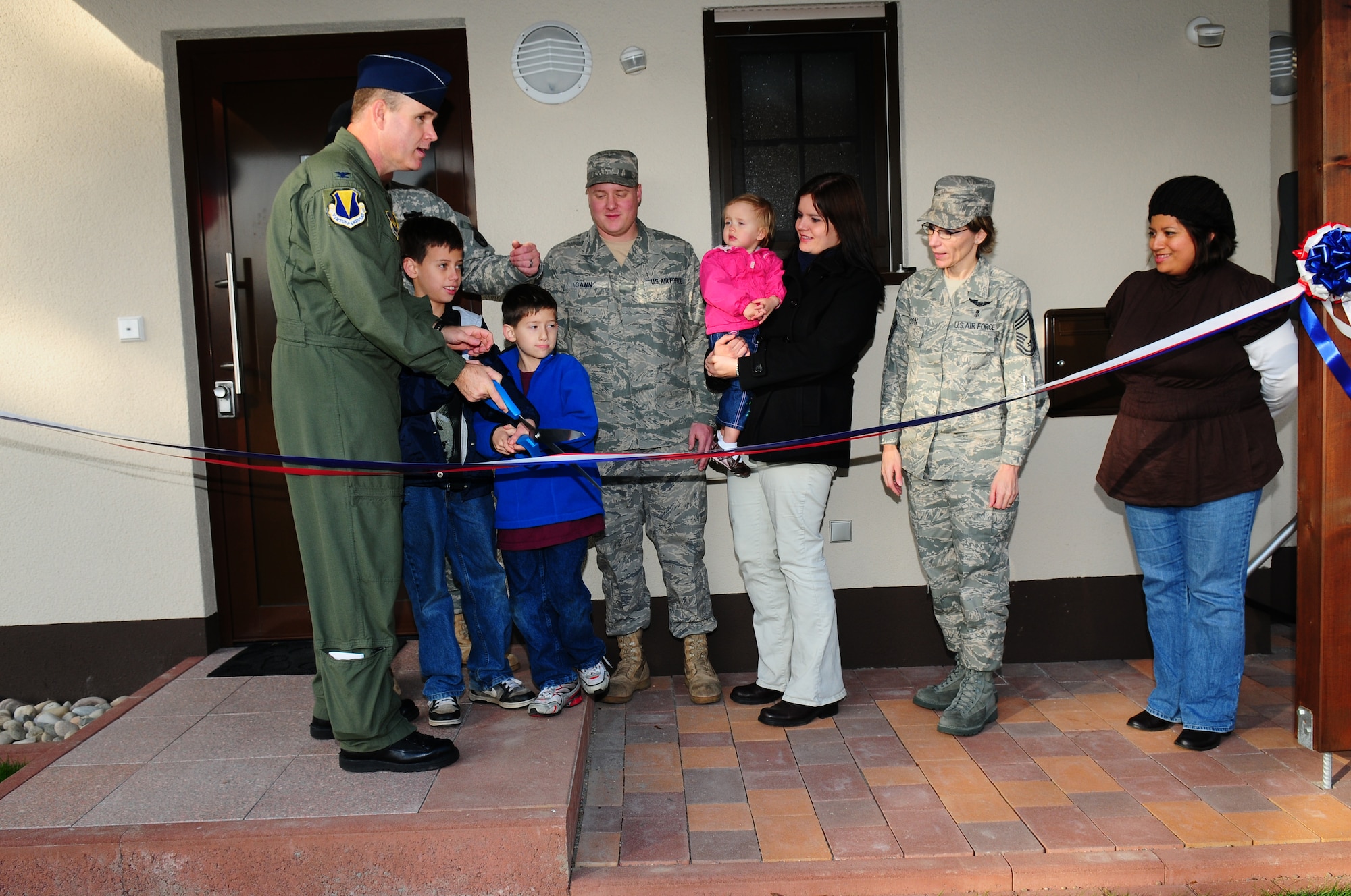 U.S. Air Force Colonel Douglas Sevier, 86th Airlift Wing vice commander, cuts a ribbon to symbolically open a newly completed four house complex at Ramstein Air Base, Germany with the families that have been issued the homes on November 18, 2009.  This set of houses marks 776 townhouse units complete of the 833 units to be built.  The $343 million dollar project is expected to be done some time next year. The new units will be open to Airman and Soldiers in the Kaiserslautern Military Community. (U.S. Air Force Photo by Staff Sgt. Jocelyn Rich)