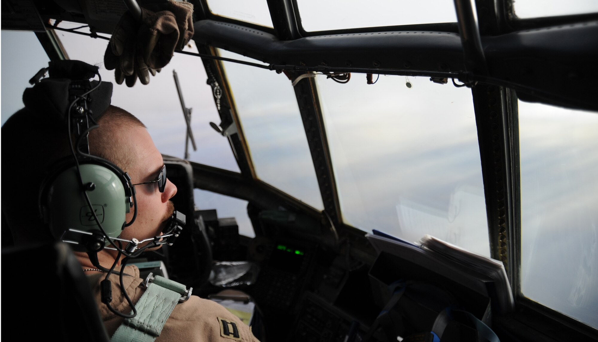 JOINT BASE BALAD, Iraq – U.S. Air Force Capt. Tom Armstrong, 777th Expeditionary Aircraft Squadron co-pilot, surveys the ground below from the cockpit of a C-130 Hercules during a mission over Iraq Nov. 13, 2009. This is the 45th mission Captain Armstrong has conducted in-theater. (U.S. Air Force photo/Senior Airman Christopher Hubenthal)

