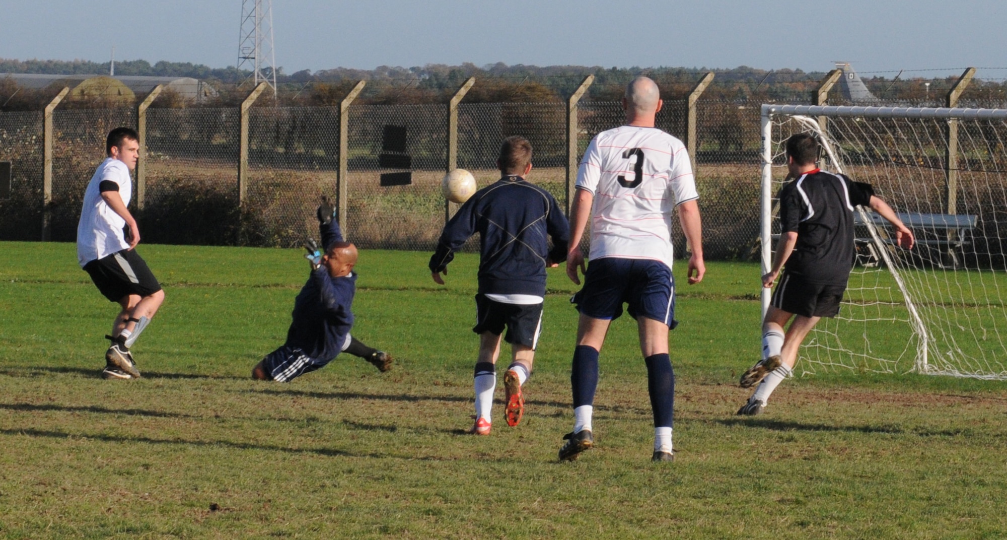 RAF MILDENHALL, England -- Ray Wisdom, 100th Logistics Readiness Squadron player, shoots and scores one of his hat trick goals against the 100th Communications Squdron in an intramural soccer semi-final match at the Hardstand Fitness Center Nov. 17. The 100th LRS took nearly had a shut out performace, but a last minute goal by Nathanial Goodman wrapped up the match 4-1. (U.S. Air Force photo/Gary Rogers)
