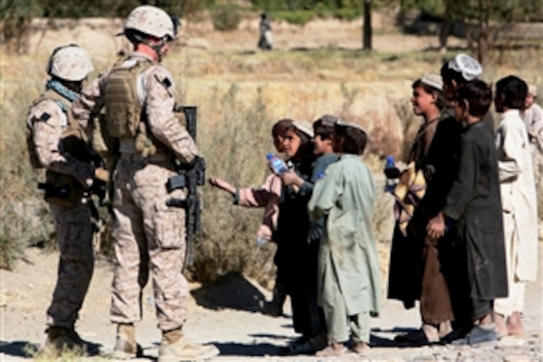 U.S. Marines hand out water to local children during a patrol of the village of Kace Satar, Afghanistan, Nov. 11, 2009. The Marines are assigned to the Company I, 3rd Battalion, 4th Marine Regiment.